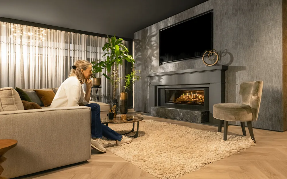 Woman on couch enjoying her electric fire Kalfire E-one 130F