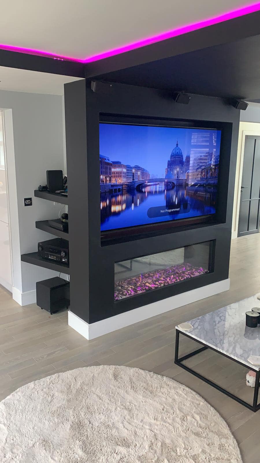 Electric fire media wall situated on a black with purple notes
